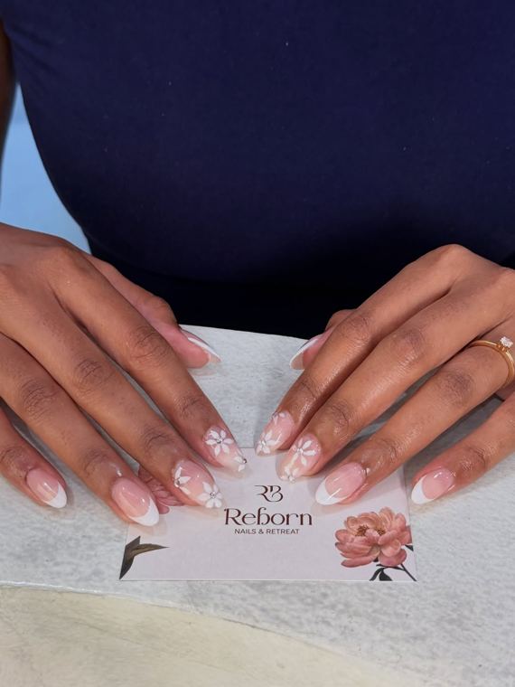 Soft French with painted flowers · on our card at Reborn Nails & Retreat Da Nang